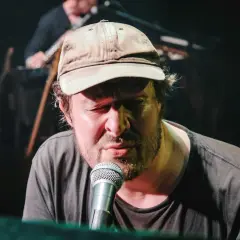 Daniel Norgren konsert. Sångaren med keps och skägg sjunger passionerat vid mikrofonen.