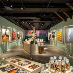 Utställning på Spritmuseum med bilder av produktion och ingredienser, samt flaskor med äppelmust.