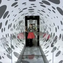 En flicka i en korridor med prickmönster på Paradox Museum. Ålder spelar ingen roll när man utforskar optiska illusioner.
