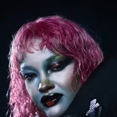 Daniela Rathana med dramatisk smink och rosa hår, redo för en konsert.