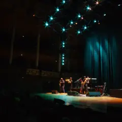 En jazzkonsert i Stockholm. Musiker spelar på scenen under stjärnliknande lampor.