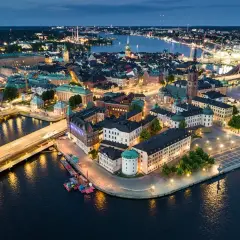 Vacker kvällsvy över Gamla Stan i Stockholm, Sverige. Upplysta byggnader och vatten reflekterar stadens ljus.