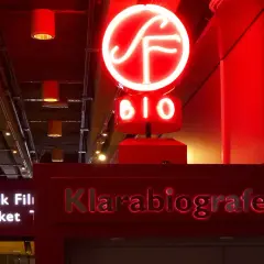 Rött neonskylt med "BIO" och en SF-logotyp ovanför entrén till Klarabiografen.