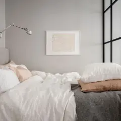 Sovalkov inspiration: Ett inbjudande sovrum med bäddad säng, vita sängkläder, rosa och vita kuddar, grå pläd och konst på väggen.