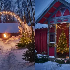 Vintermagi med julpynta utomhus. Snöklädda granar och gnistrande ljusslingor skapar en mysig julstämning vid en röd stuga och en eldfat.