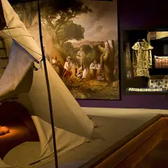 En utställning på etnologiska museet visar en tipi, en målning av ursprungsbefolkning och en samling kläder och föremål.