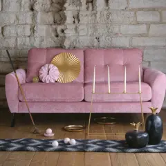 Rosa sammetssoffa med dekorativa föremål som ger soffa vardagsrum inspiration. En golfklubba, ljusstakar och ananasskulpturer skapar en unik atmosfär.