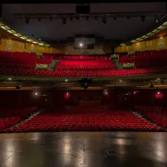 Tomma röda sammetsstolar i en teatersalong, redo för publiken på China Teatern Stockholm.