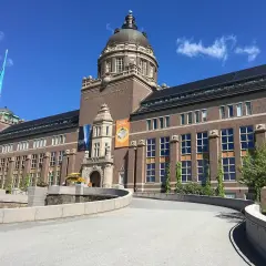 Imponerande byggnad för Naturhistoriska riksmuseet i Stockholm. En blå flagga vajar stolt.