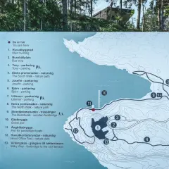 Karta över Artipelag i Gustavsberg visar leder, byggnader och parkeringar. En besökare planerar sin promenad.