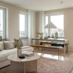 Ljust och luftigt vardagsrum med soffa, soffbord och matplats. Vår inredning skapar en harmonisk och inbjudande atmosfär.
