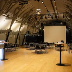 Stora, ljusa lokaler med trägolv och synliga takbjälkar, redo för ett event i workshop Stockholm.