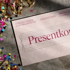 Presentkort till orgelkonsert i Stockholm. Konfetti och serpentiner runt ett presentkort för Sveriges Radios Symfoniorkester.