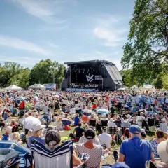 Stor publik njuter av en utomhuskonsert med Kungliga Filharmonikerna. Soligt och glatt!
