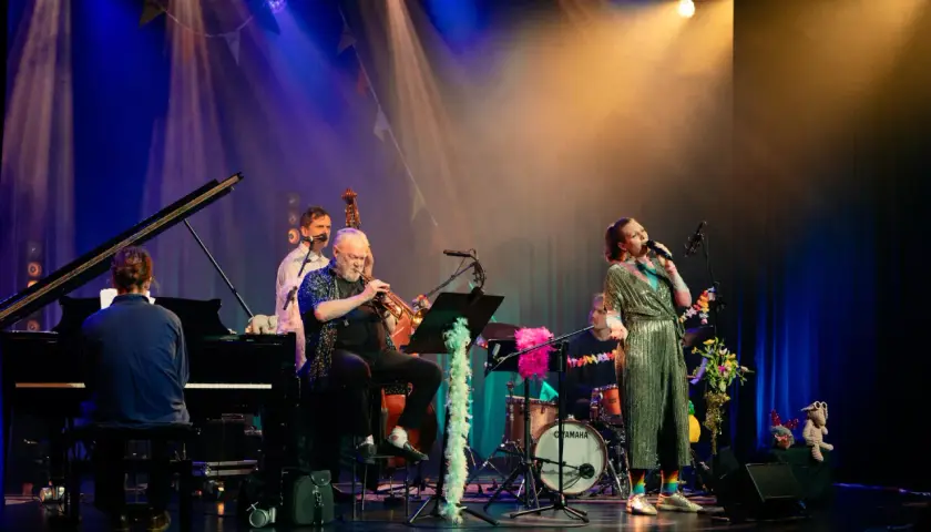En jazzkvartett spelar på scenen, en del av stockholms jazzfestival program. Sångerskan i glittrig klänning, trumpetare, basist och pianist.