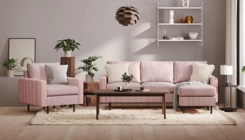 Ett mysigt rosa vardagsrum med en stor soffa, fåtölj, soffbord och en fluffig matta. Växter och konst ger liv åt rummet.