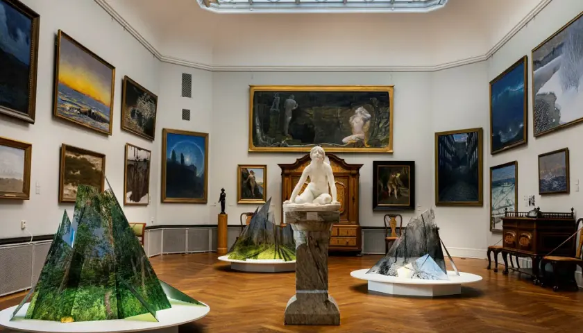 Konsthall med målningar och skulpturer. I förgrunden syns moderna installationer som speglar naturen. Thielska museet bjuder på en fascinerande blandning av gammalt och nytt.