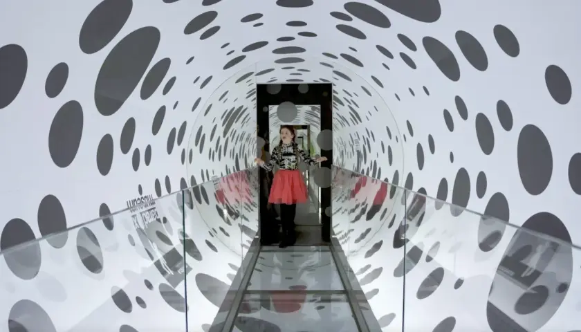 En flicka i en korridor med prickmönster på Paradox Museum. Ålder spelar ingen roll när man utforskar optiska illusioner.