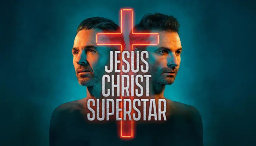 Två ansikten, som spegelbilder, flankerar ett neonkors. Texten "JESUS CHRIST SUPERSTAR STOCKHOLM" lyser i silver.