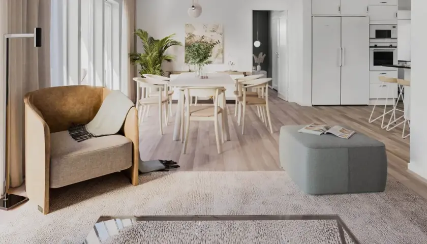 Ett ljust och luftigt vardagsrum med matplats i klassisk nordisk design. En bekväm fåtölj och en grön pall skapar en inbjudande atmosfär.
