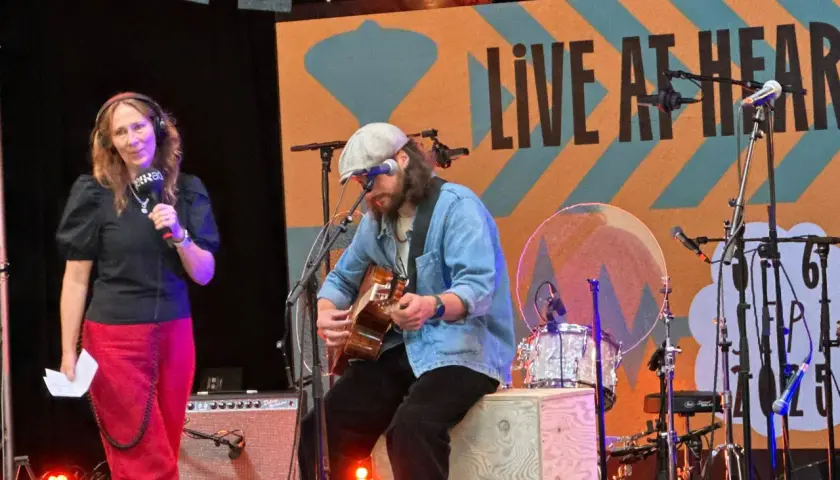 Jens Hult konsert med en kvinna som håller mikrofon och en man som spelar gitarr på scenen.