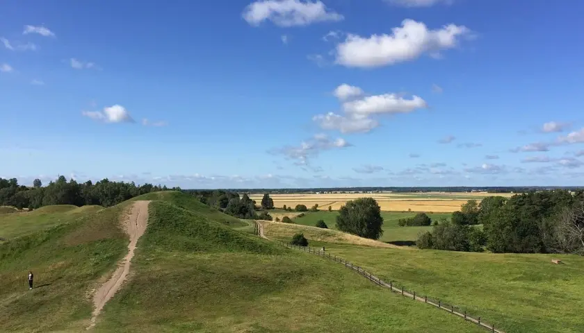 Gröna kullar och en stig leder till en fantastisk utsikt över fält och skog. Upplev Uppsala från ovan!