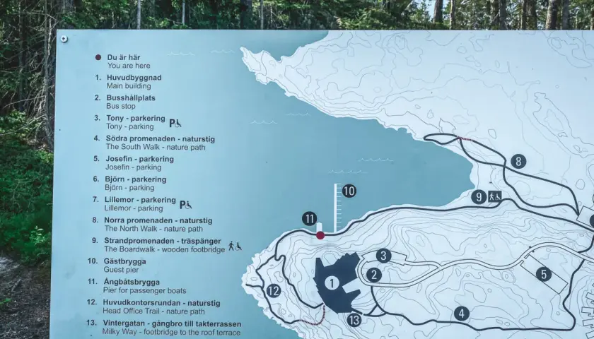 Karta över Artipelag i Gustavsberg visar leder, byggnader och parkeringar. En besökare planerar sin promenad.