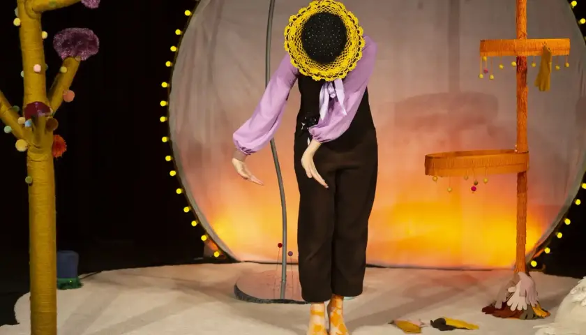 En docka med solros-huvud på scenen, en del av dockteater Stockholm.