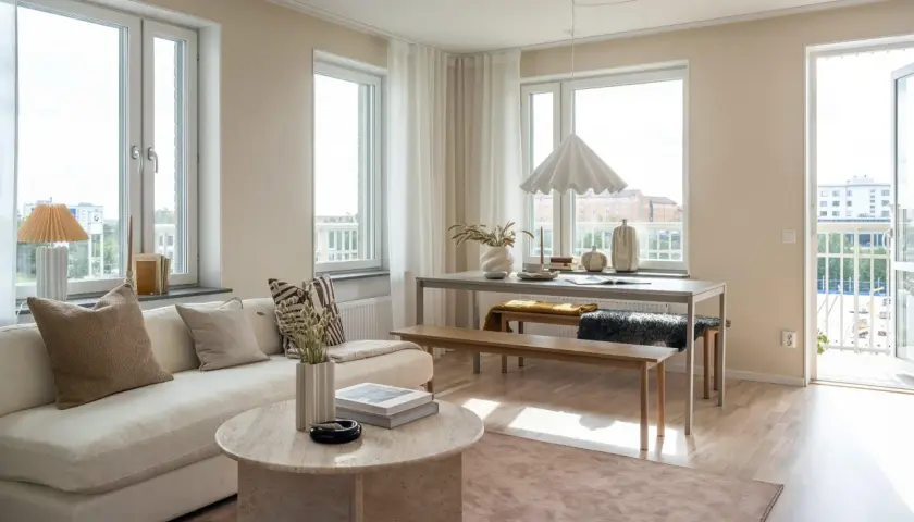 Ljust och luftigt vardagsrum med soffa, soffbord och matplats. Vår inredning skapar en harmonisk och inbjudande atmosfär.