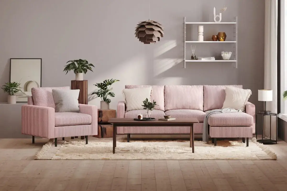 Ett mysigt rosa vardagsrum med en stor soffa, fåtölj, soffbord och en fluffig matta. Växter och konst ger liv åt rummet.