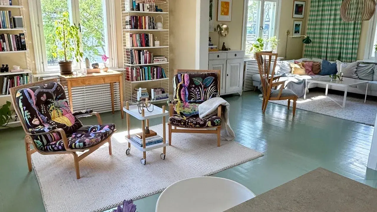 Ljust och inbjudande vardagsrum med bokhyllor, färgstarka fåtöljer och en soffgrupp. En harmonisk känsla av feng shui vardagsrum.