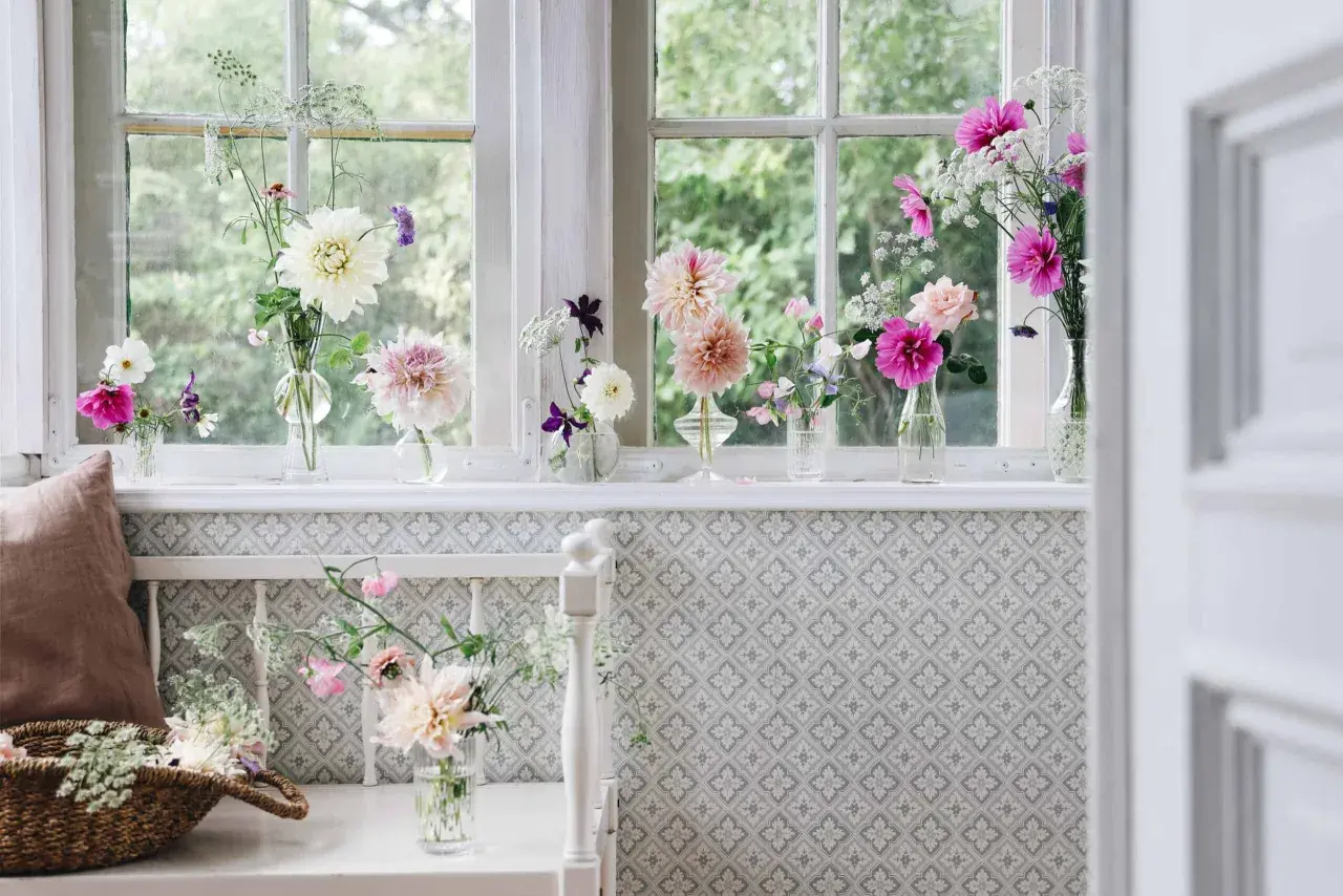 Vackra blommor i vaser pryder fönsterbrädan och skapar en inbjudande inredning.