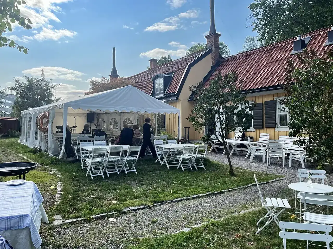 Festligt dukat utanför Ekermanska malmgården med tält, bord, stolar och ett liveband.