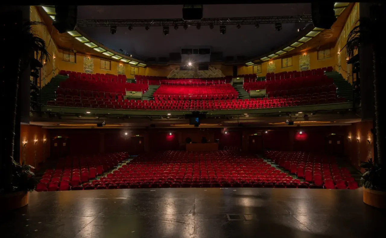Tomma röda sammetsstolar i en teatersalong, redo för publiken på China Teatern Stockholm.
