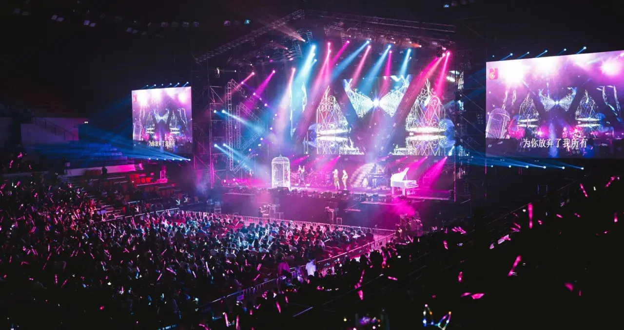 Publiken njuter av en färgsprakande konsert idag, med artister på scenen och stora skärmar som visar deras framträdande.