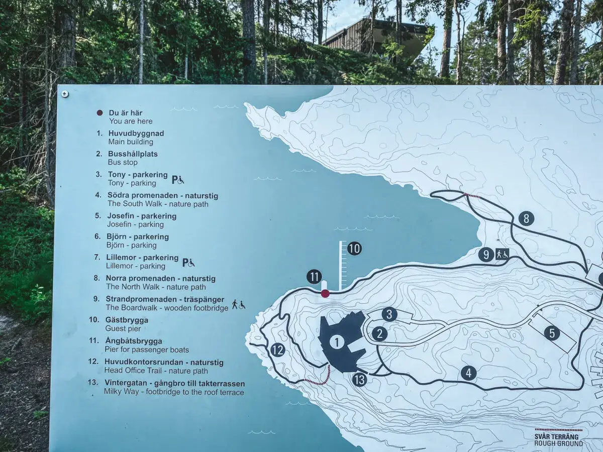 Karta över Artipelag i Gustavsberg visar leder, byggnader och parkeringar. En besökare planerar sin promenad.