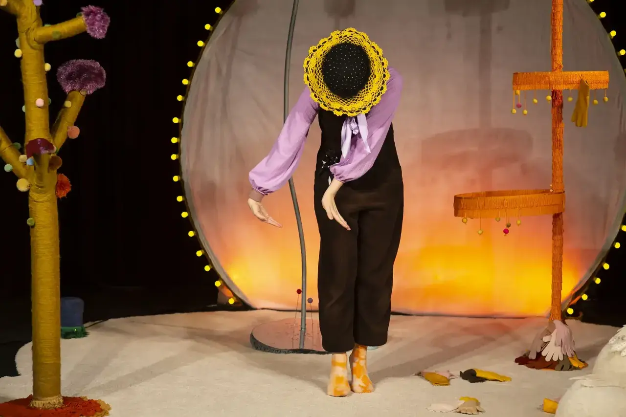 En docka med solros-huvud på scenen, en del av dockteater Stockholm.