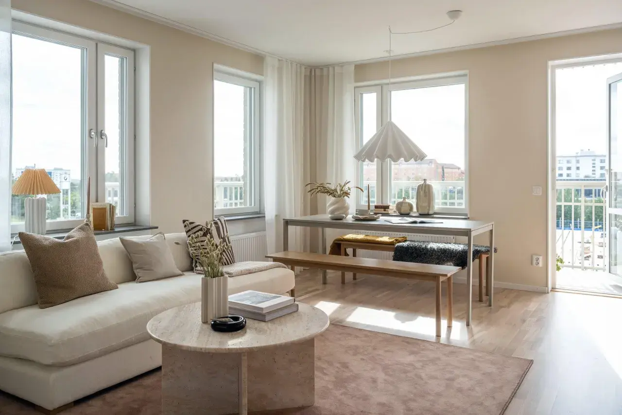 Ljust och luftigt vardagsrum med soffa, soffbord och matplats. Vår inredning skapar en harmonisk och inbjudande atmosfär.