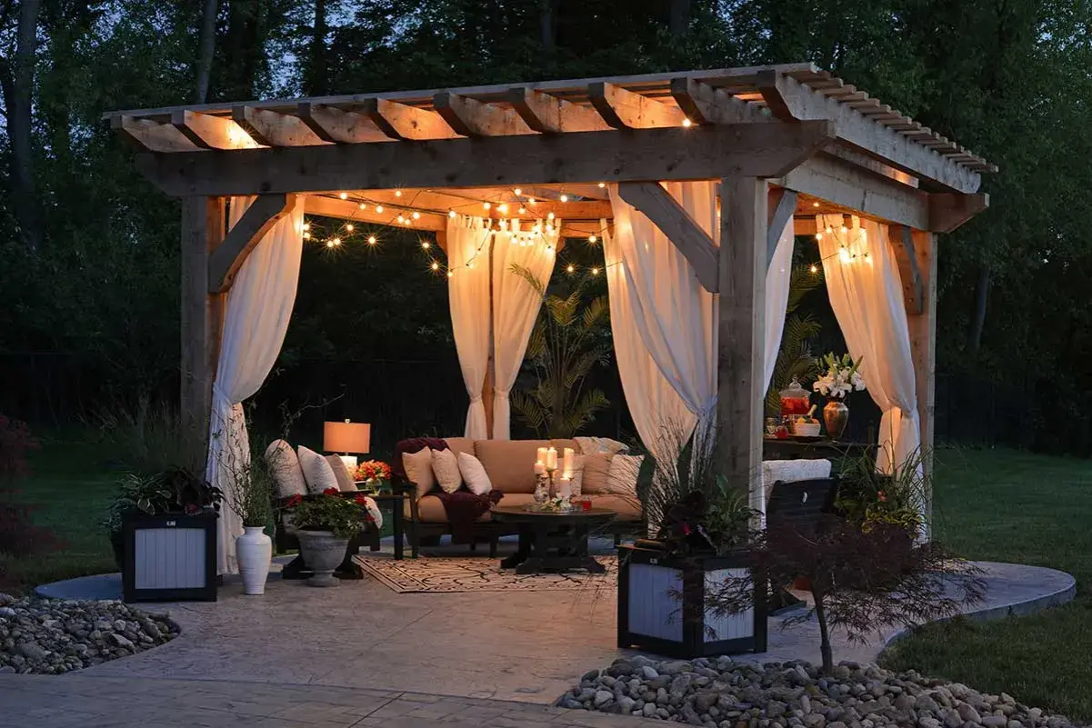 Mysig altan inspiration med draperade gardiner, ljusslingor och bekväma möbler. Perfekt för sommarkvällar.