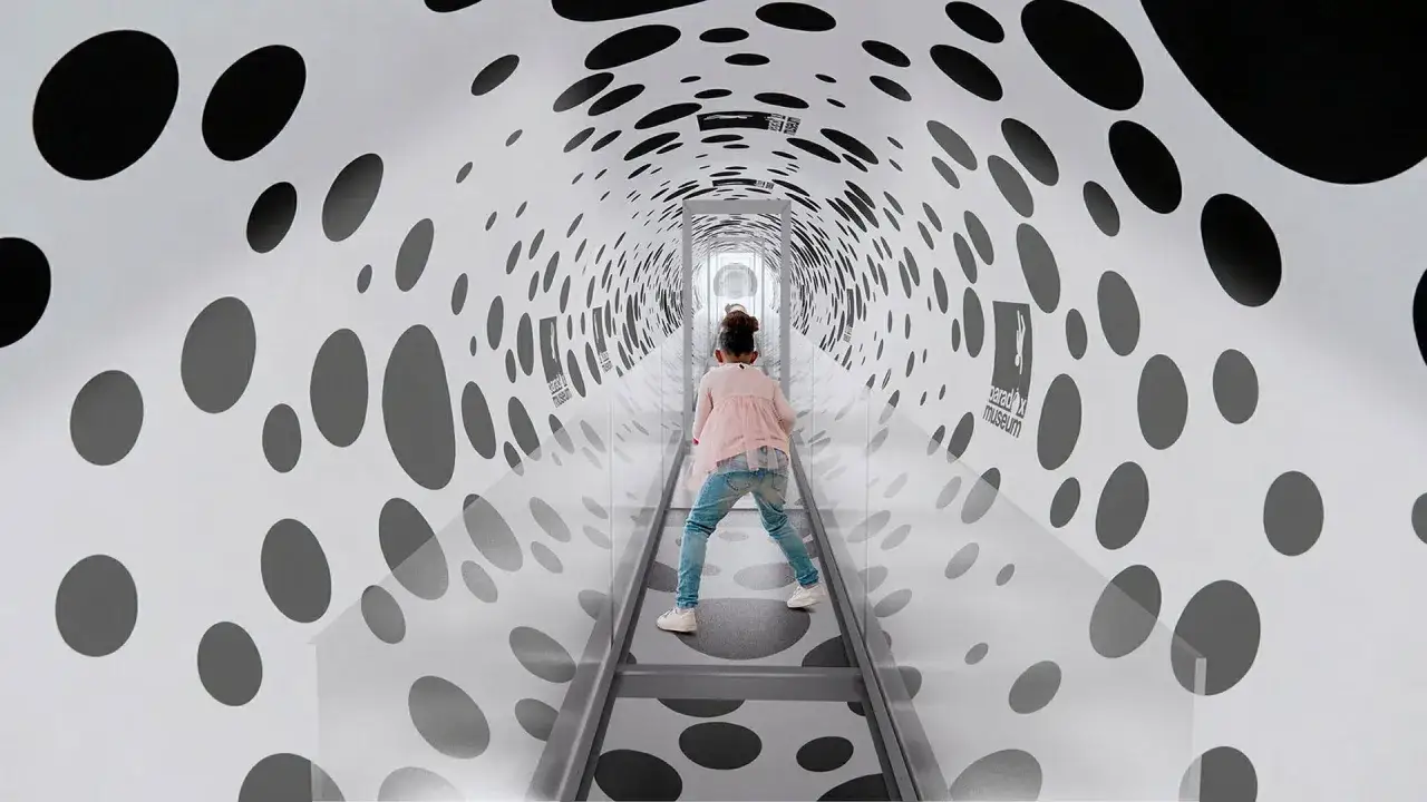 Barn går genom en tunnel med prickar på Paradox Museum Stockholm, en optisk illusion.