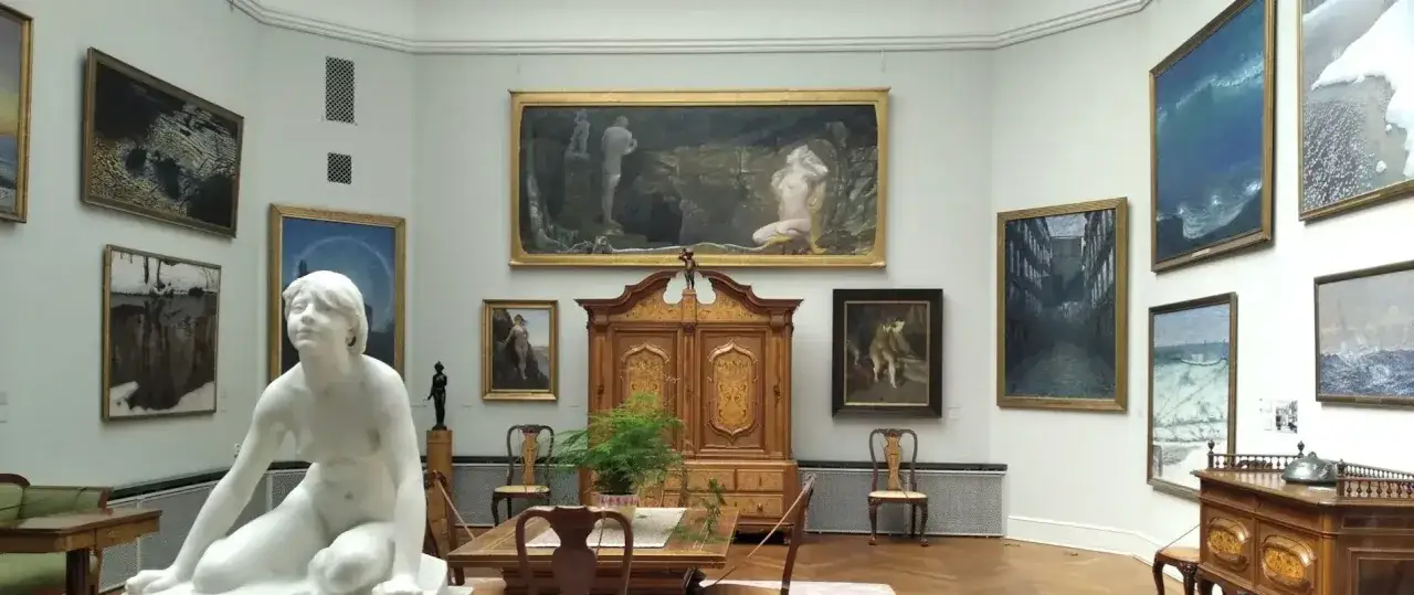 En sal på Thielska museet med skulptur och målningar.