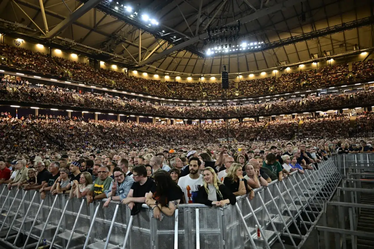 Publiken jublar på Friends Arena under en konsert med Bruce Springsteen. Tusentals fans trängs framför scenen.