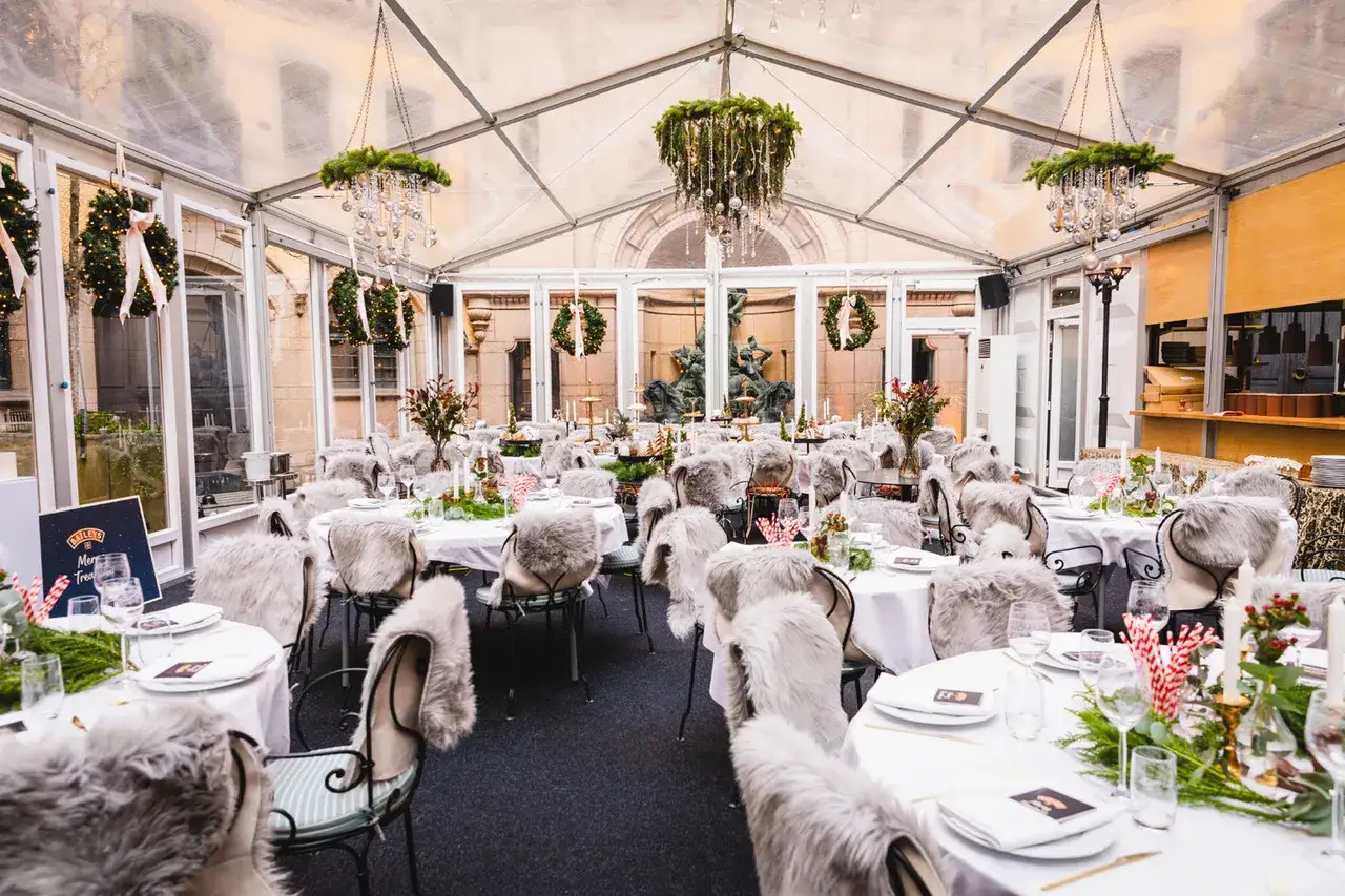 Vintermysig festlokal med juldekorationer och pälsbeklädda stolar. En perfekt plats för en julfest vid Hallwylska bar.