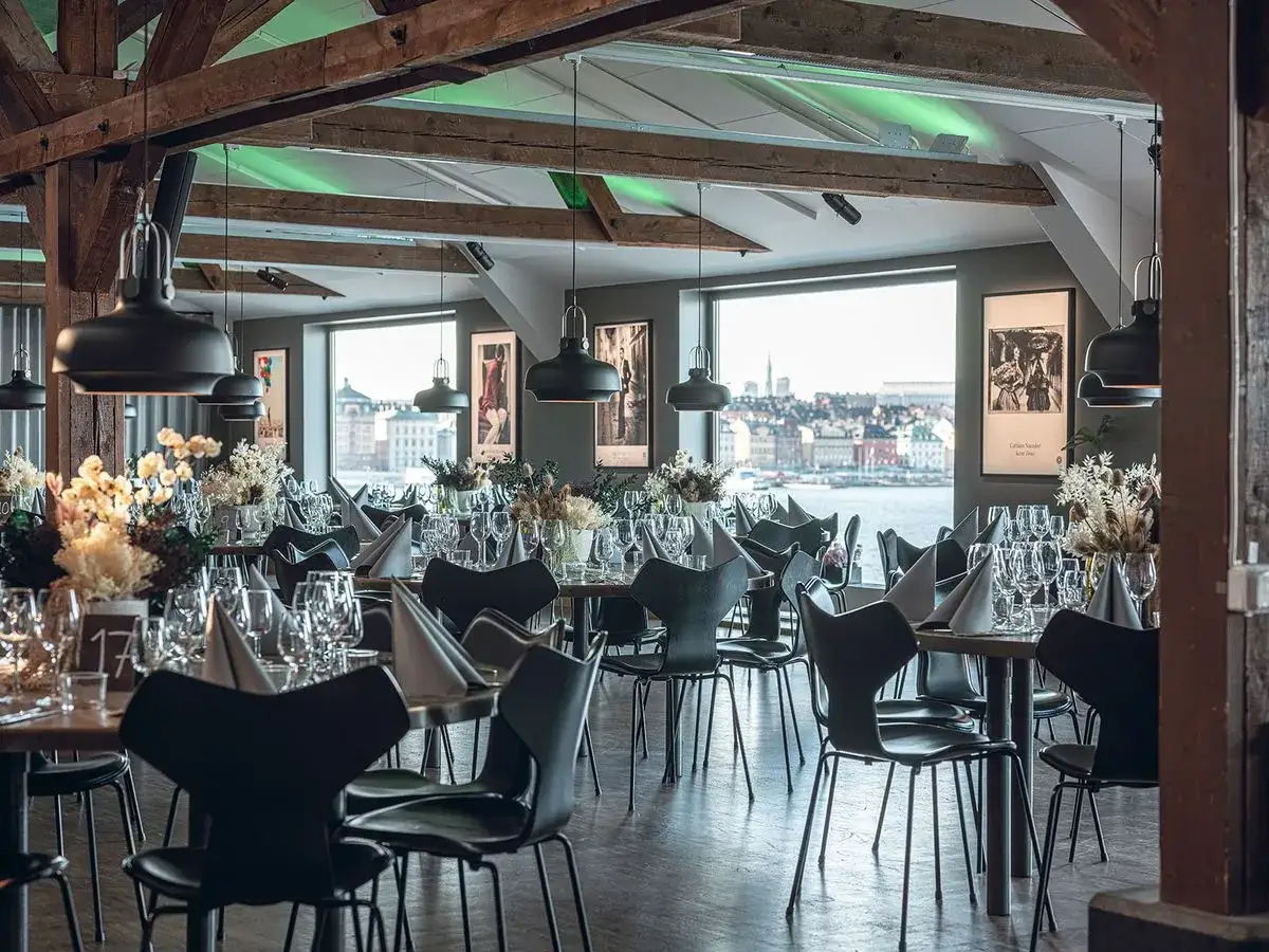 Vackert dukade bord med blommor och glas, redo f&ouml;r ett fotografiskt julbord med utsikt &ouml;ver vattnet.