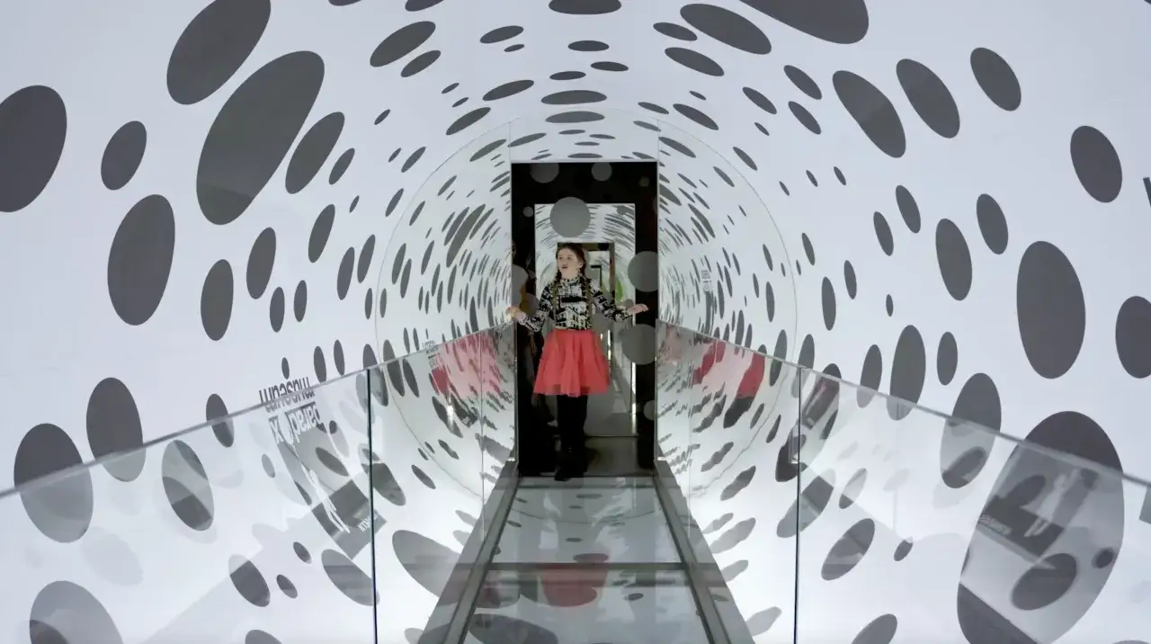 Flicka går genom en tunnel med prickar, en optisk illusion på Paradox Museum Stockholm.