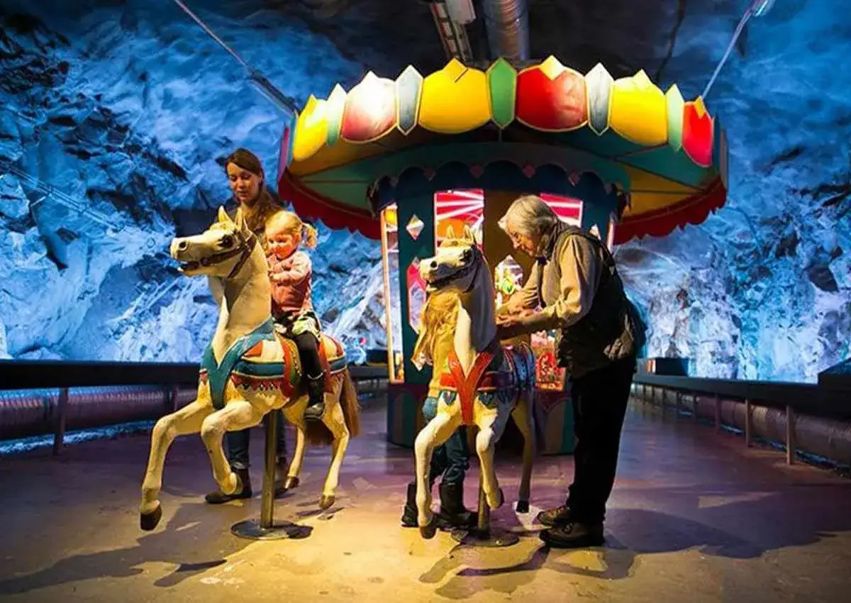 Familj njuter av en karusell i ett museum i Stockholm. Ett perfekt gratis museum stockholm barn-tips för en rolig dag!