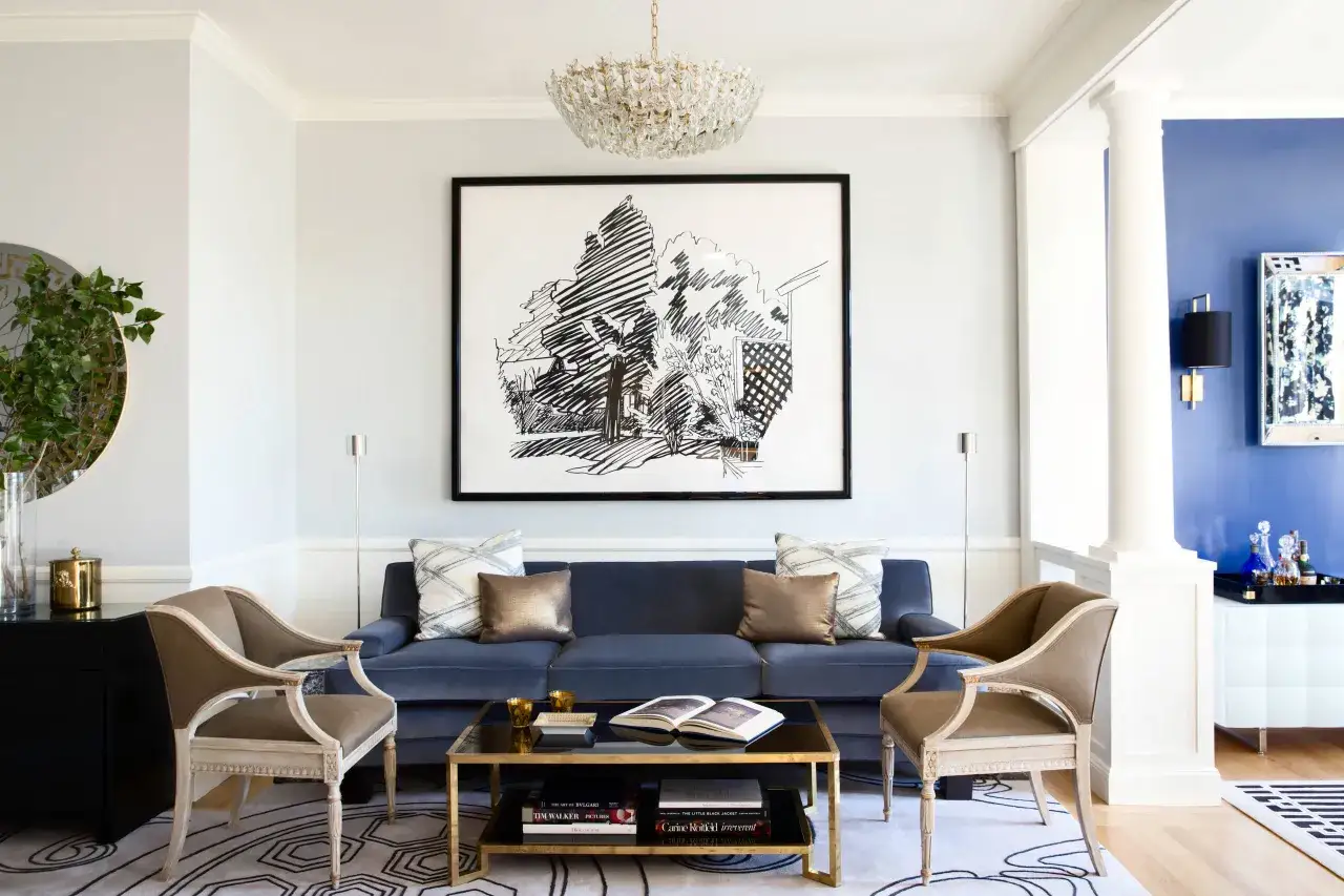 En elegant matta med geometriskt mönster kompletterar den blå soffan och skapar en harmonisk sittgrupp.
