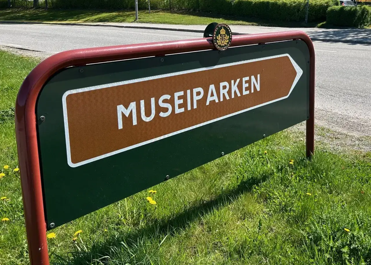 Skylt som pekar mot Museiparken Stockholm. En gr&ouml;n skylt med en brun pil och texten 