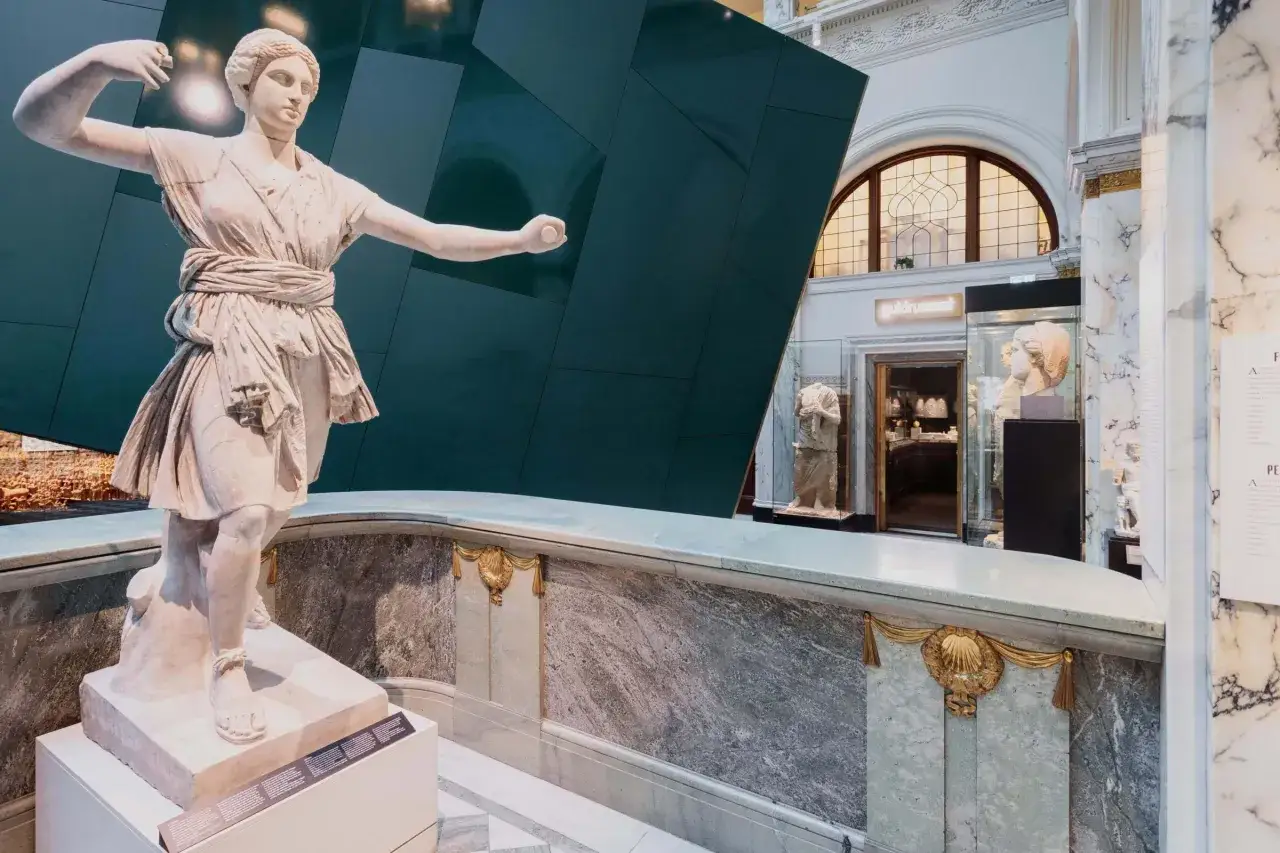 Antik staty i ett annorlunda museum i Stockholm. Marmor och en modern grön vägg skapar en unik miljö.